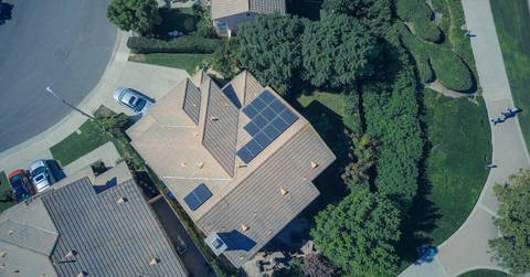 File image: Aerial view of suburban house with rooftop solar panels and trees