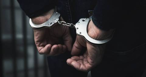 Person's hands in handcuffs during police custody