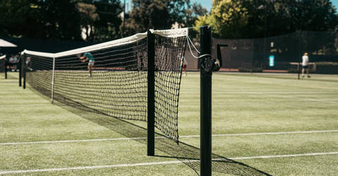 File image: Grass tennis courts with net post and players in background