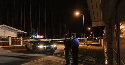 File image: Night street scene with police car, officers, and crime scene tape