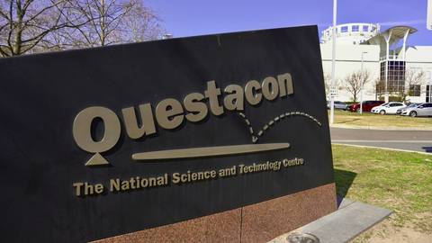 Questacon sign and building exterior, parking lot, bare trees, clear sky
