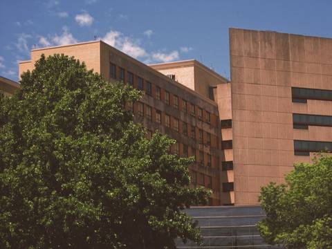 File image: Two large brutalist institutional buildings behind green trees