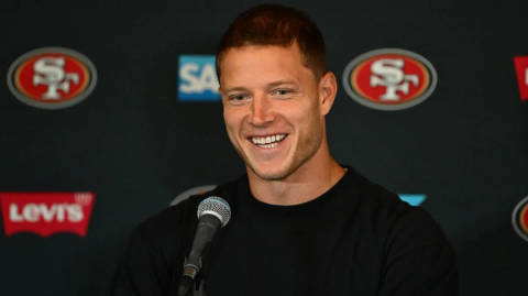 Man speaking at microphone with 49ers and SAP logos on backdrop behind him