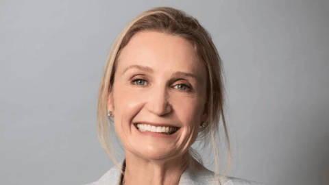 Camilla Drover. Professional headshot of a smiling woman against neutral gray background