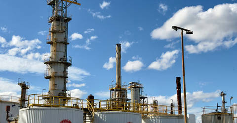 File image: Modern oil refinery with distillation towers and processing equipment under clear sky.
