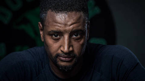 Khalid Baker. Head-and-shoulders portrait of an adult man, serious expression, dark background