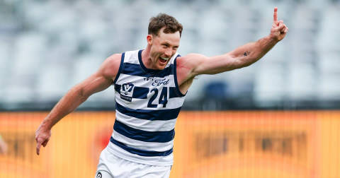 Jed Bews. Geelong player in navy-white striped jersey number 24 celebrating with arms spread at oval