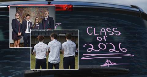 School students in uniforms and white shirts with autographs on grass