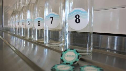 Row of numbered glass containers with sample labels for water quality testing