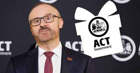 Man in suit and glasses speaking at ACT Government official event