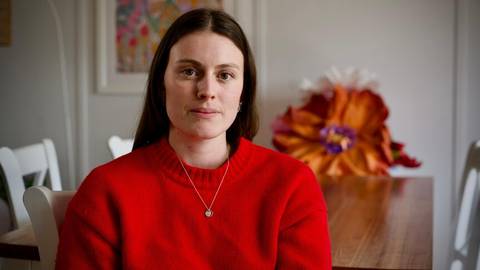 Tessa Coddington. Woman in red sweater, portrait in residential interior with flowers
