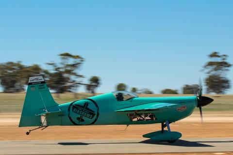 File image: Turquoise aerobatic aircraft taking off from grass airfield