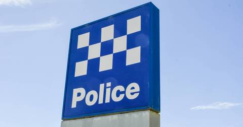 Blue police station sign with white checkered pattern