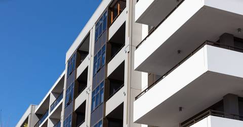 Modern apartment building with balconies and blue-tinted glass windows