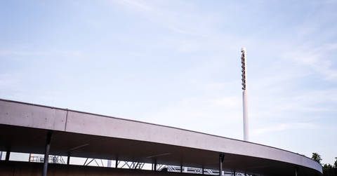 File image: Curved concrete stadium exterior with tall white floodlight mast