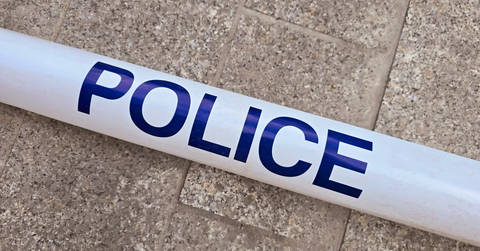 File image: White police tape with blue lettering on concrete ground