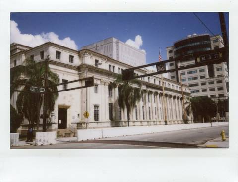 File image: White classical courthouse with columns, palm trees, and American flag. Exterior view.