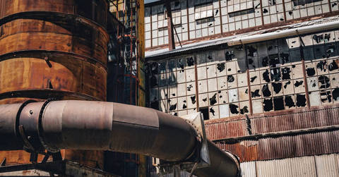 File image: Deteriorated industrial facility with broken window panels and metal pipe structures