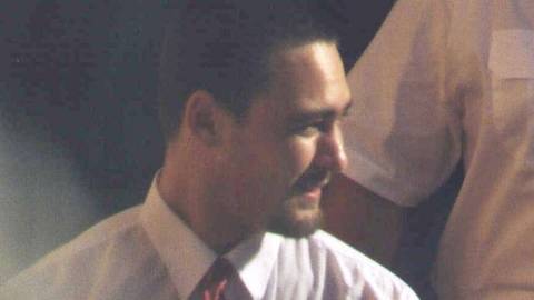 James Vlassakis. Man in shirt and tie photographed indoors in warm lighting