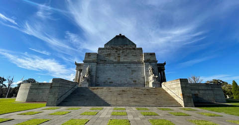 Stone Hall of Memory building with grand steps and distinctive dome architecture under clear blue sky.