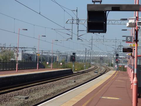 Contemporary railway platform with electrified overhead lines and modern station infrastructure