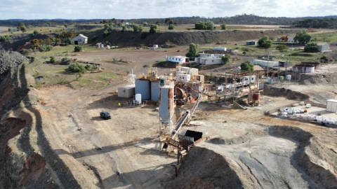 Aerial view of industrial mining facility with blue tanks and excavation equipment in rural Western Australia