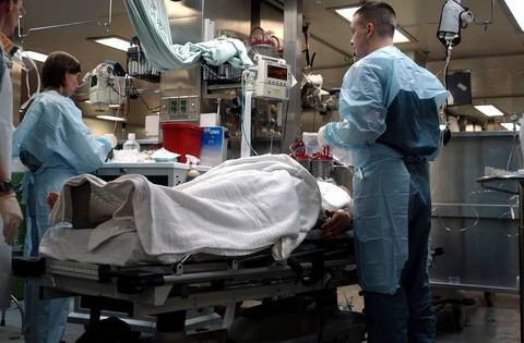 Medical staff attending to patient on bed in hospital emergency department