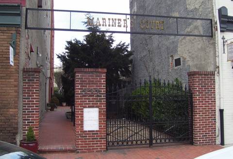 File image: Brick coroner's court entrance with iron gates and ivy-covered archway, neutral institutional setting.