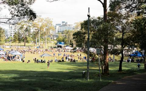 File image: Crowd gathered on grassy oval with tents and eucalyptus trees