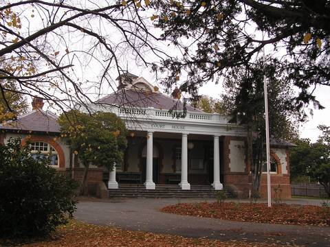 File image: Red brick courthouse with white columns and flagpole, autumn trees