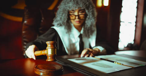 File image: Judge in formal attire with gavel at courtroom bench during legal proceeding