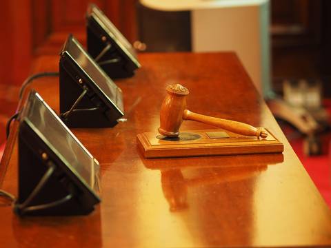 File image: Wooden gavel on podium with microphones, courtroom setting
