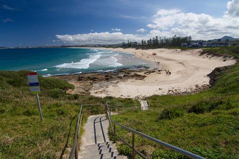 File image: Stairs descending to a sandy beach with turquoise ocean