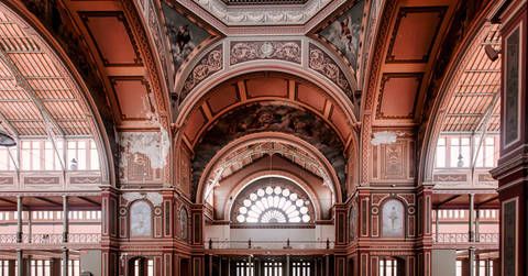 Ornate red arches and decorative architecture of a historic building interior