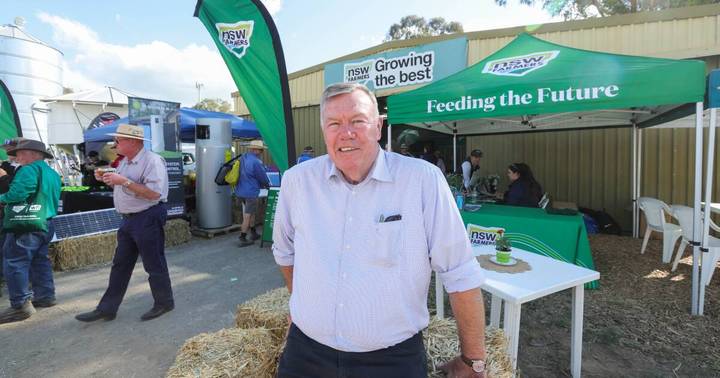 David Farley. Man at NSW Farmers outdoor exhibition with green marquees and agricultural branding