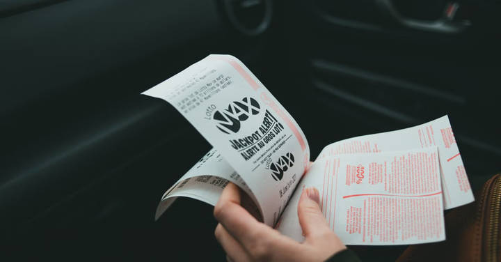 File image: Single hand holding a lottery ticket or print-out with text