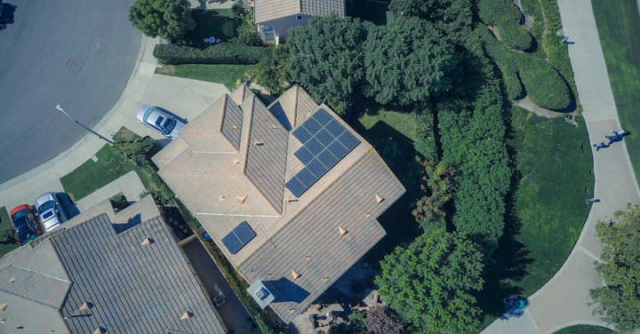 File image: Aerial view of suburban house with rooftop solar panels and trees