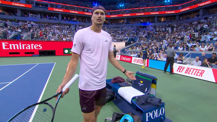Alexander Zverev. Tennis player in purple shirt during US Open match on hard court with crowd