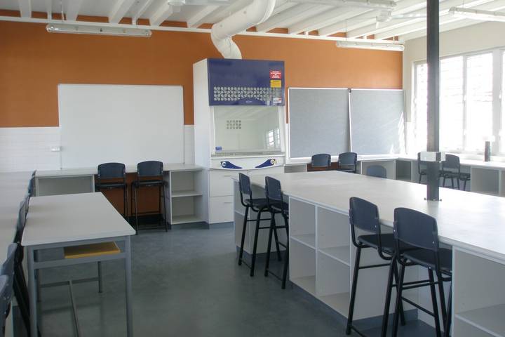 File image: Empty contemporary classroom with white desks, orange walls, teaching equipment