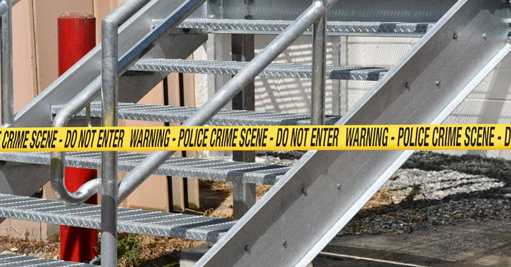 File image: Yellow police tape cordoning off metal exterior stairs at a building.