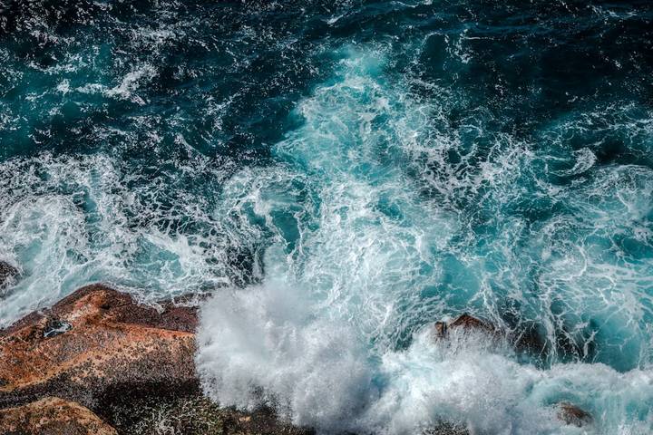 File image: Aerial view of ocean waves crashing on rocky coastline