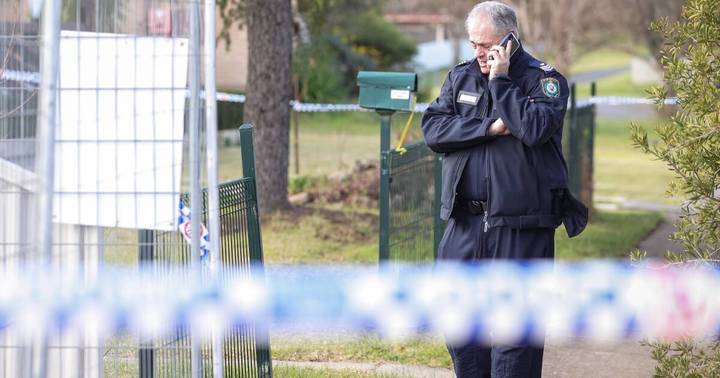 Dwayne Brian Williams. Uniformed officer speaking on phone at residential location with police cordon visible