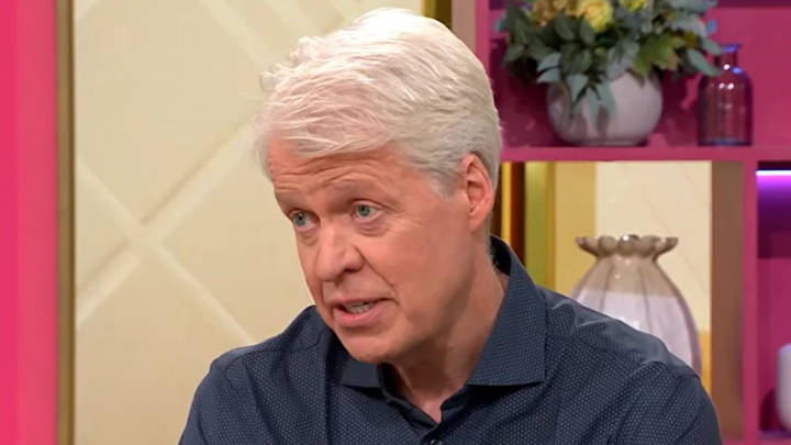 Earl Spencer. Man with white hair in dark blue shirt speaking in TV studio