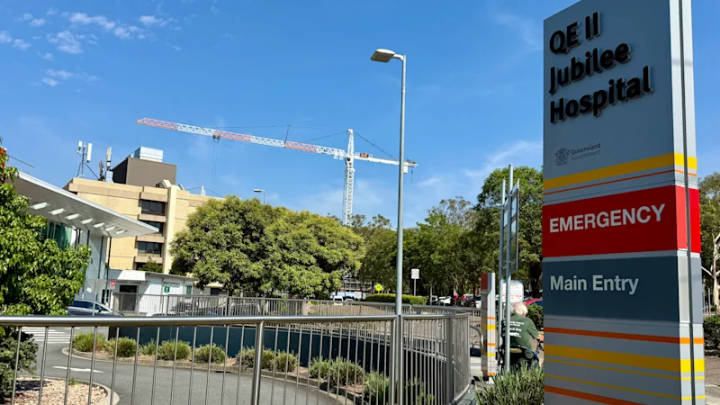 Hospital exterior with construction crane and emergency department signage