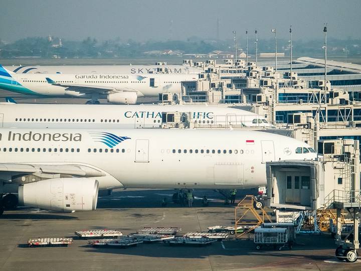 File image: Multiple passenger aircraft parked at airport terminal with ground support equipment and facilities.