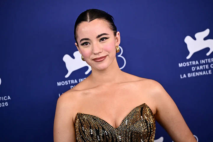 Ashley St. Woman in gold sequined strapless gown at Venice Film Festival backdrop