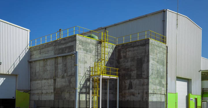 Industrial building with concrete blocks, yellow safety railings, and metal structures