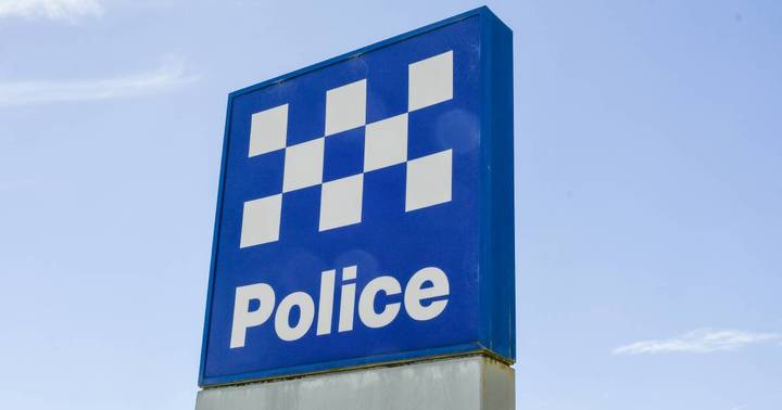 Blue police station sign with white checkered pattern