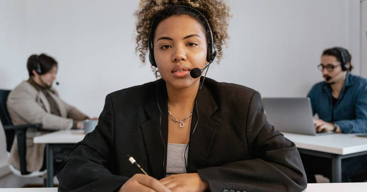 File image: Woman in headset at support centre desk, professional mental health service setting.