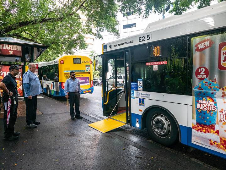 File image: Queensland bus with open doors at urban bus interchange with bystanders